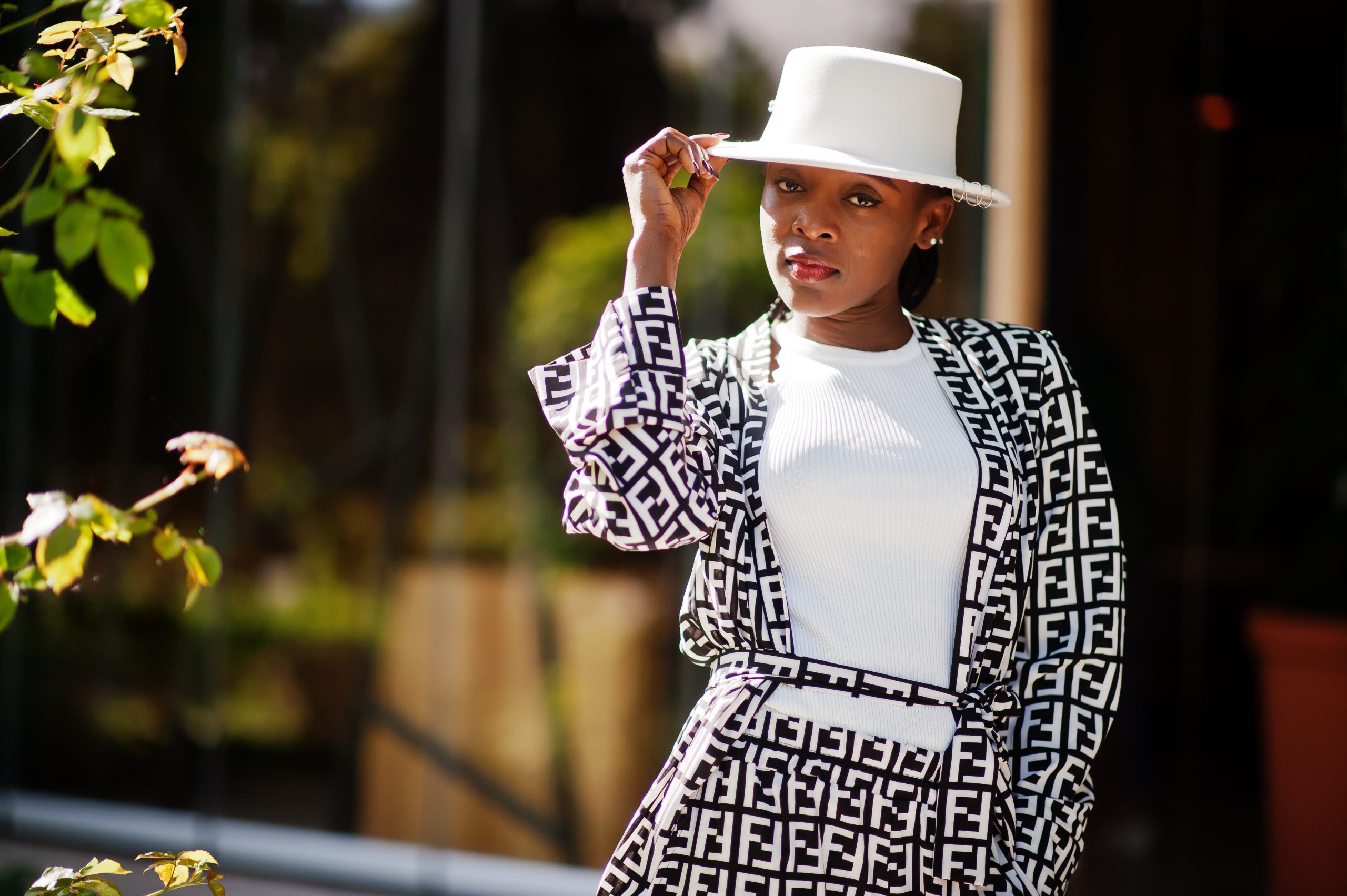 Beautiful african american woman natural makeup wear fashion clo Beautiful african american woman natural makeup wear fashion clothes casual black and white dress code office style total blouse and pants suit and hat.